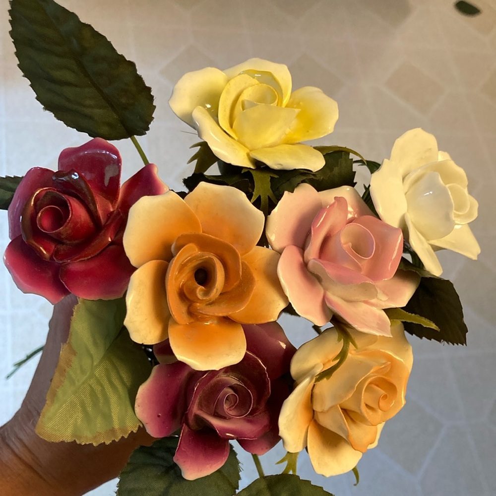 Seven porcelain flowers, assorted colors with 11 inch stems with bendable wire.